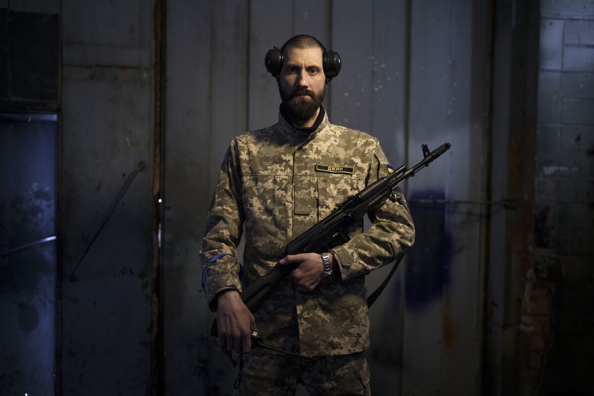 Sergiy Volosovets, 30, actor-turned-commander with the Territorial Defense Forces, poses for a photo in Brovary, on the outskirts of Kyiv, Ukraine, Wednesday, March 30, 2022. Volosovets now commands a unit of 11 men and oversees the military training of other volunteers at a base northeast of the capital, Kyiv. They are old, young, local, foreign, often new to war. Thousands of people have volunteered to join Ukraine’s Territorial Defense Forces and resist Russia’s invasion. The Associated Press this week spent time with some of them. (AP Photo/Felipe Dana)