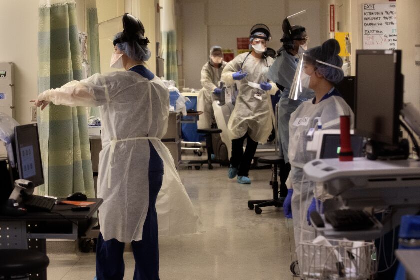LOS ANGELES, CA-APRIL 23, 2020: Medical staff, wearing protective gear, work inside a Covid 19 isolation area, inside the emergency department at Los Angeles County+USC Medical Center in Los Angeles, where patients with the virus are being treated. (Mel Melcon/Los Angeles Times)