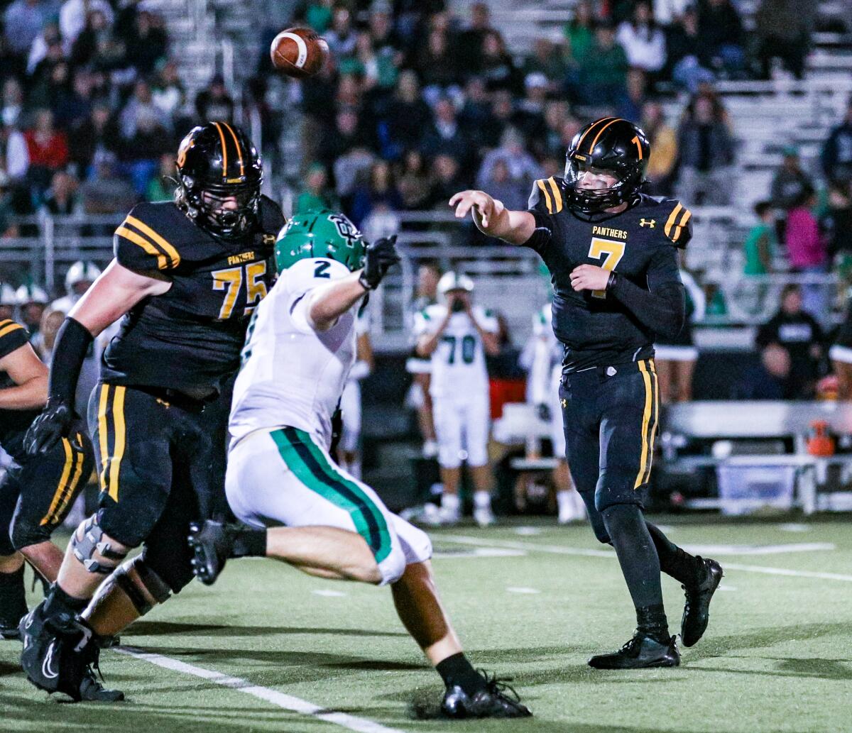 Brady Smigiel of Newbury Park throws a pass under pressure during a win over Thousand Oaks.