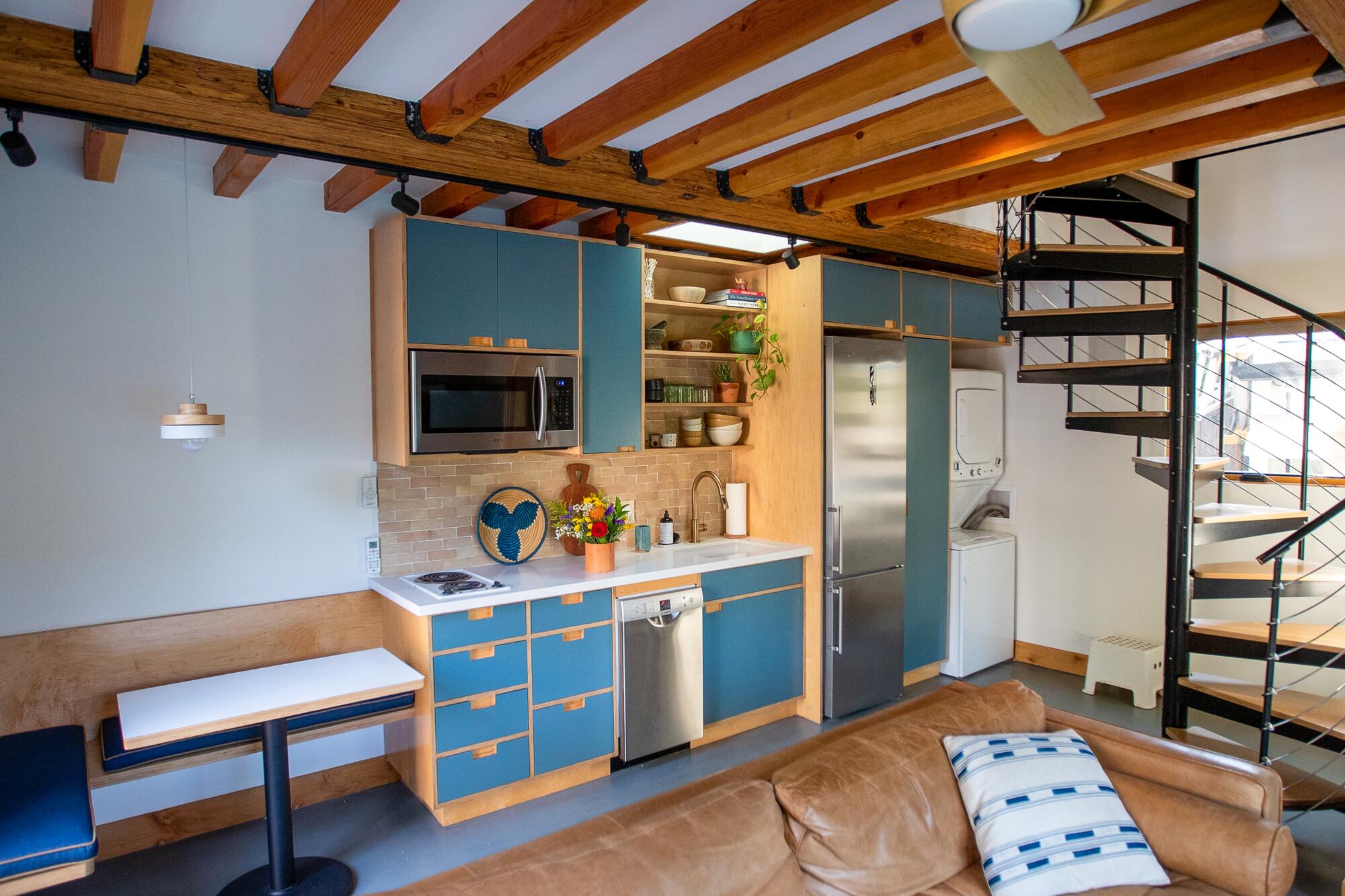 A kitchen with blue cabinets and a spiral staircase