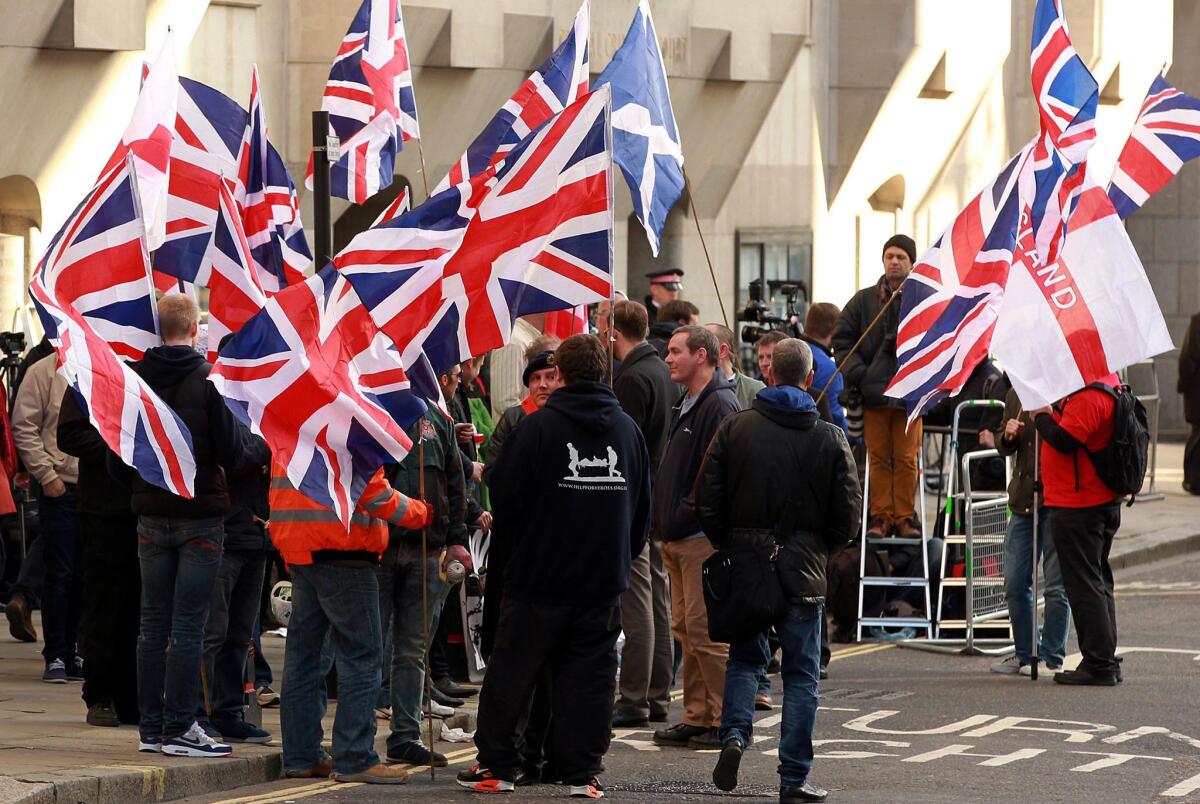 Demonstrators wave flags outside the Old Bailey in London on Wednesday ahead of the sentencing of Michael Adebolajo and Michael Adebowale, who were convicted of murdering 25-year-old fusilier Lee Rigby.