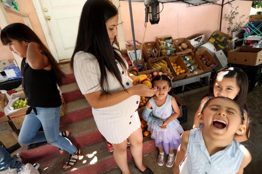 LOS ANGELES, CA - JULY 27, 2020 - - Maria Reyes, second from left, spends time with her daughters Marilyn, 9, from left, Darlene, 4, Sophia, 6, and Leilani, 5, right, near their home in Los Angeles on July 27, 2020. All four of the children have attended Head Start, one of three major publicly-funded preschool programs serving low-income California families. California's youngest learners are returning to the classroom. But in the state's neediest zip code, 90011, in where the family lives, preschools remain closed. Such programs are considered essential to closing racial and economic achievement gaps among school-aged children - yet tens of thousands of eligible preschoolers can't get spots, including almost 2,000 Maria's zip code, the state's most underserved. As private preschools across California prepare to reopen, experts fear those in public programs will be left behind, and that thousands of existing spots could disappear. (Genaro Molina / Los Angeles Times)