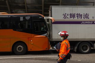 Un paramédico revisa el lugar de un accidente en una autopista, el viernes 24 de marzo de 2023, en Hong Kong. (AP Foto/Louise Delmotte)