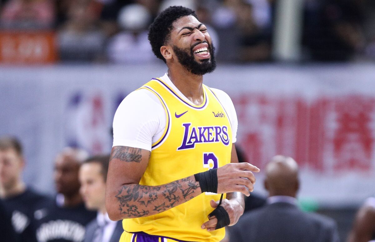 Lakers forward Anthony Davis grimaces after sustaining a thumb injury during the first half Saturday.