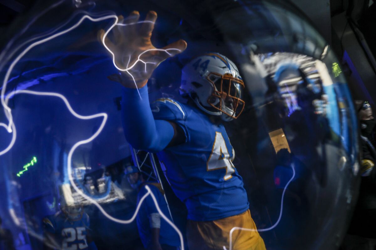 Chargers outside linebacker Kyzir White touches a lightning orb.