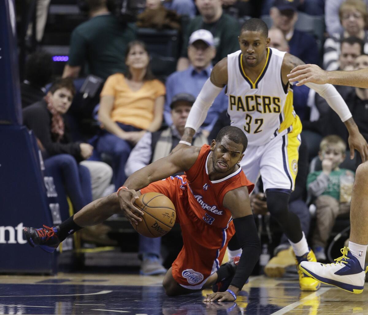 Clippers point guard Chris Paul falls to one knee while trying to maintain possession of the ball against the Pacers in the second half.