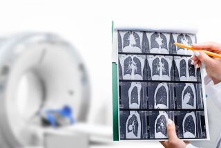 Radiologist showing tomography scan of a patient's lungs over of CT machine.