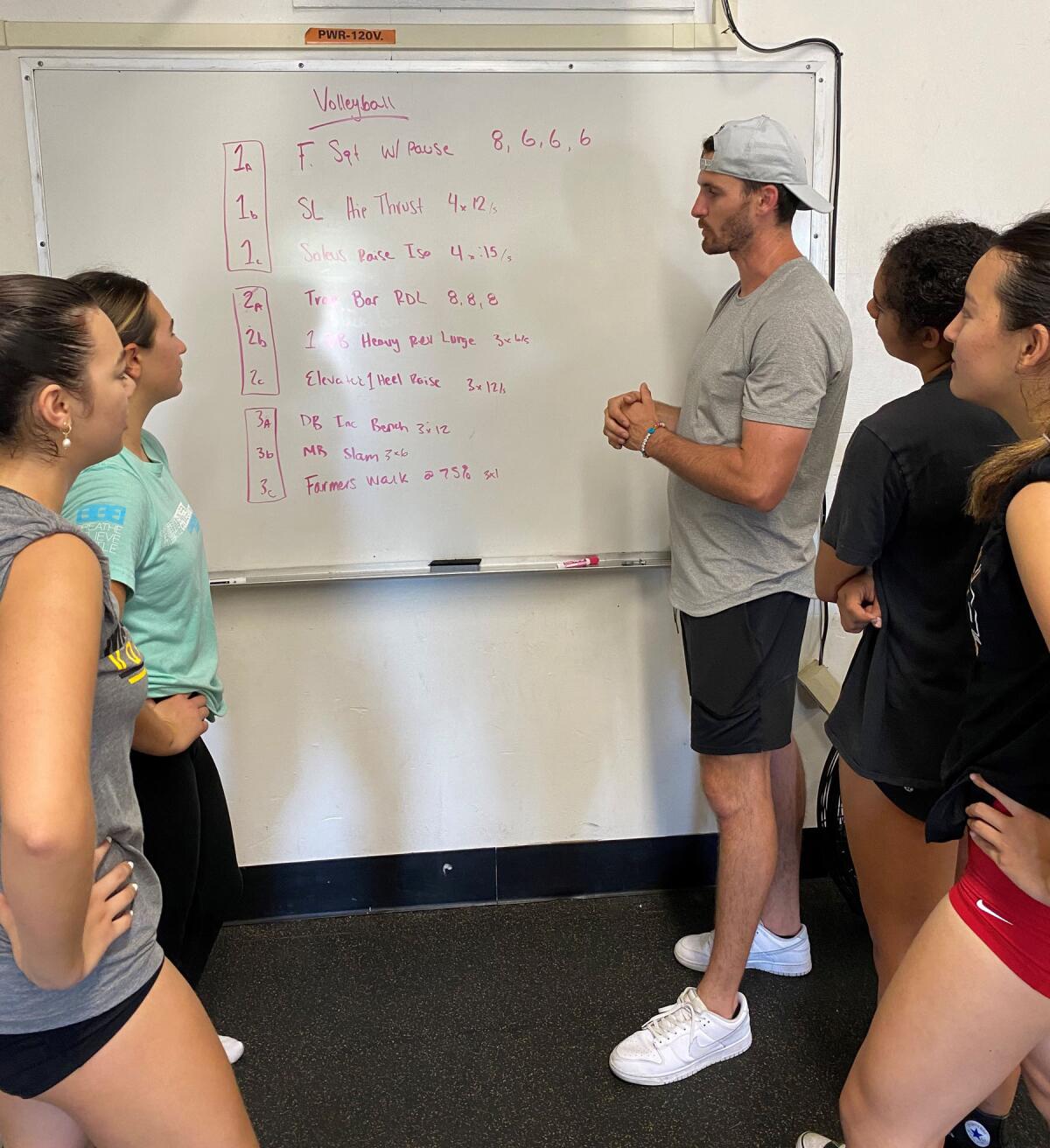Mission Bay High volleyball players listening to Coach Teddy Anderson talk about their workout plan.