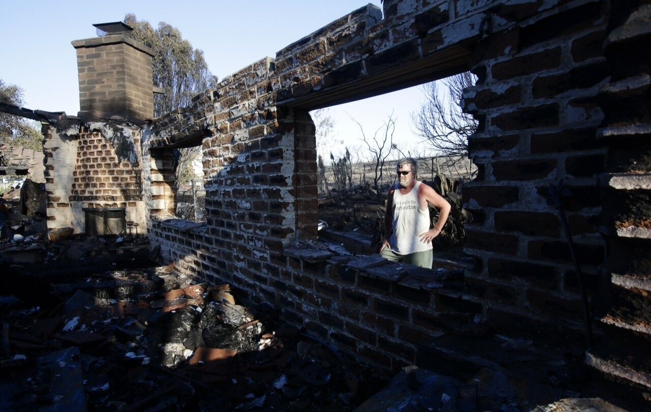 Gilbert Cope surveys a destroyed home in the 1700 block of Skimmer Court in Carlsbad.