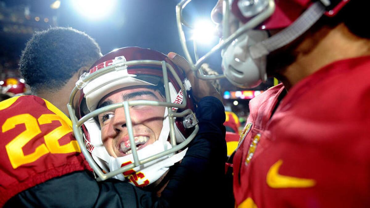 USC kicker Chase McGrath is mobbed by his teammates after making the game-winning field goal in double overtime against Texas at the Coliseum.