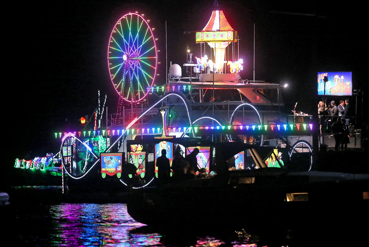 A large vessel decked out in a Christmas circus theme, moves along the route.