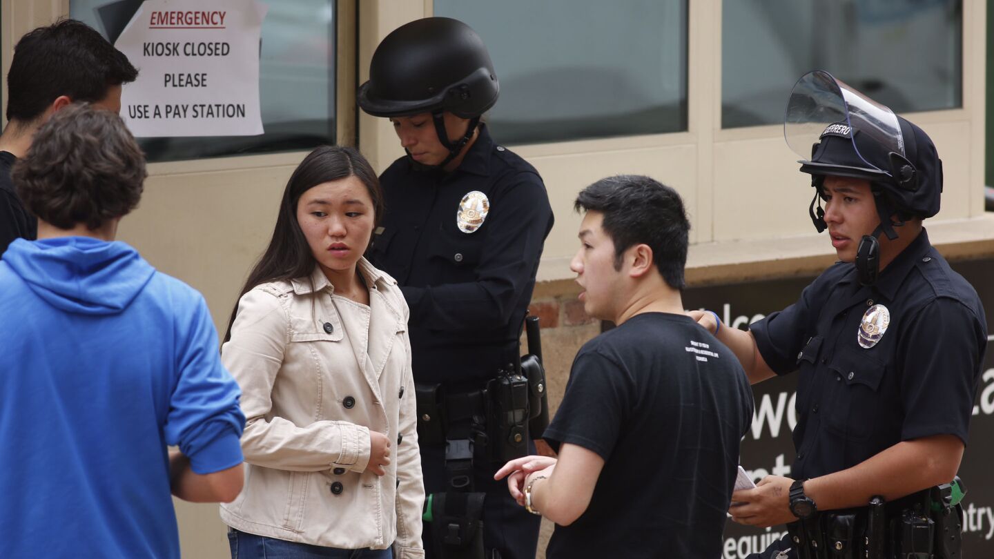 Police officers check students after a shooting at UCLA on Wednesday.