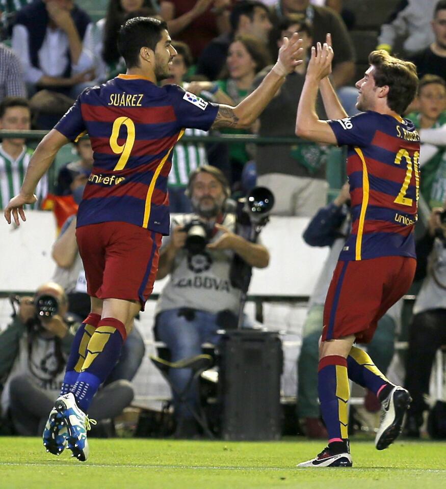 El delantero uruguayo del FC Barcelona, Luis Suárez (i), celebra con Sergi Roberto tras marcar el segundo gol ante el Betis, durante el partido de Liga en Primera División disputado en el estadio Benito Villamarín, en Sevilla.