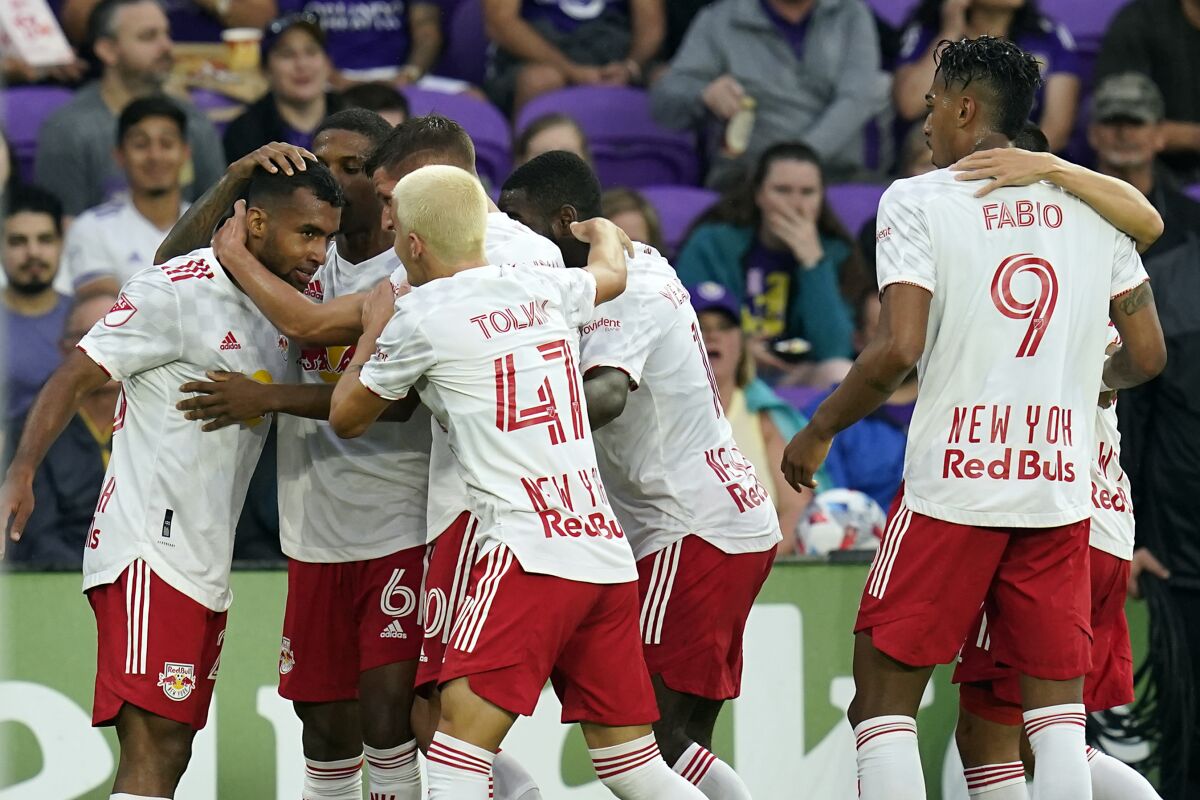 New York Red Bulls midfielder Cristian Casseres Jr, left, celebrates with teammates, including defender John Tolkin (47) and forward Fabio (9), after scoring a goal against Orlando City during the first half of an MLS soccer match, Saturday, July 3, 2021, in Orlando, Fla. (AP Photo/John Raoux)