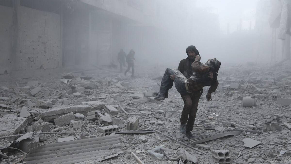 A wounded man is carried after an airstrike on the rebel-held besieged town of Arbin, on the outskirts of the Syrian capital of Damascus on Jan. 2.