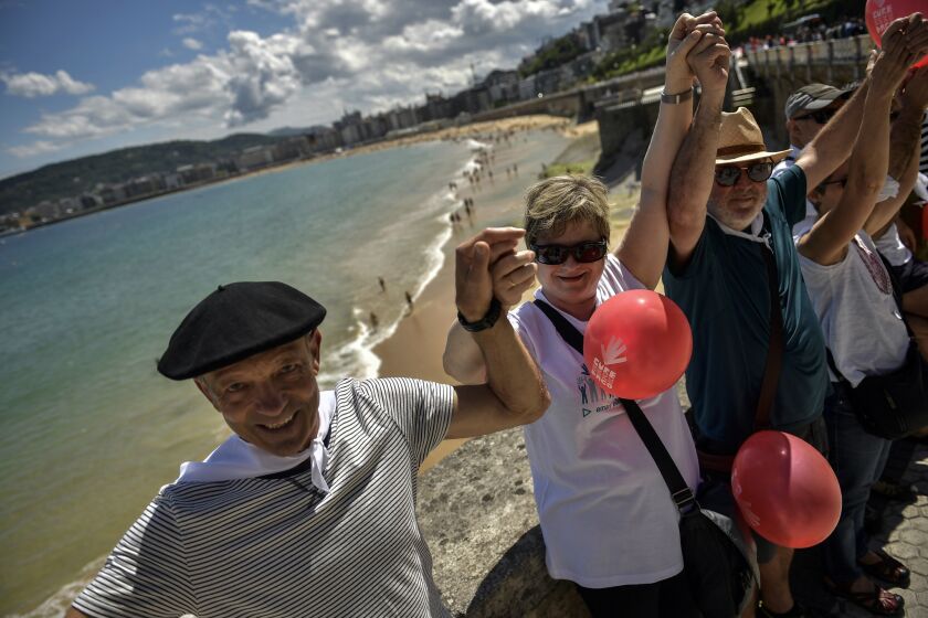 People gather along La Concha beach, as thousands independence of demonstrators make a human chain calling for the independence of the Basque Country with the slogan ''Our Right to Decide'' or in Basque language, '' Gure Esku Dago'', in the Basque city of San Sebastian, northern Spain, Sunday, June 10, 2018. Thousands of demonstrators marched in a large human chain in the Basque cities of Vitoria, Bilbao and San Sebastian for half an hour Sunday afternoon. (AP Photo/Alvaro Barrientos)