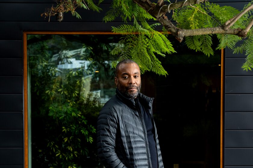 Director Lee Daniels in a puffy coat and sweatpants standing on his deck