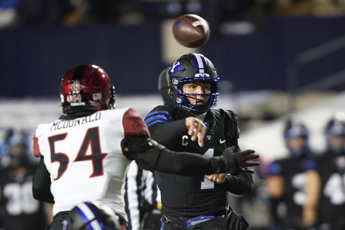BYU quarterback Zach Wilson throws a pass as San Diego State linebacker Caden McDonald (54) defends during the first half of an NCAA college football game Saturday, Dec. 12, 2020, in Provo, Utah. (AP Photo/George Frey, Pool)