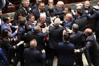 5-Star Movement lawmaker Leonardo Donno, center top, is protected by parliament employees from other lawmakers during brawl in the lower chamber of deputies at the Italian parliament, in Rome, Wednesday, June 12, 2024. Tensions in Italy's lower house over a government proposal that opponents says will further impoverish the poorer south erupted into a fist-fight that sent an opposition lawmaker to the hospital. (Mauro Scrobogna/LaPresse via AP)
