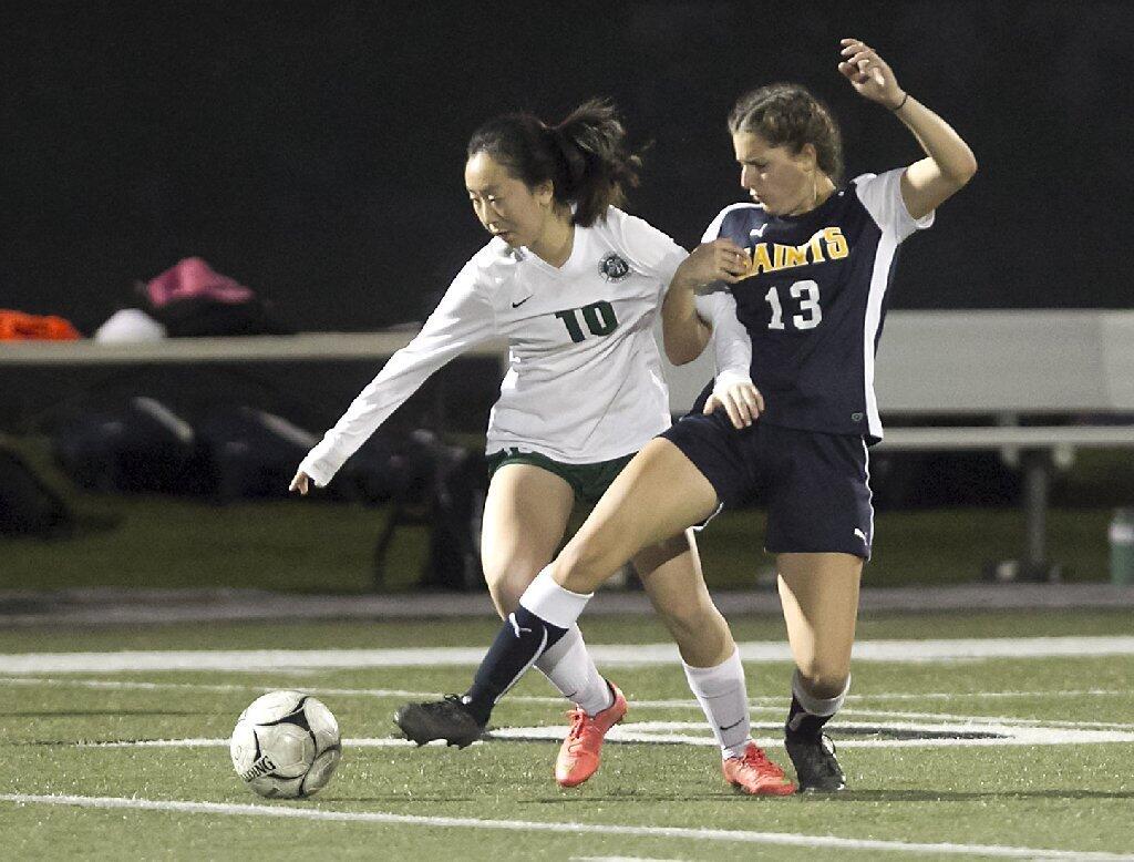 Sage Hill's Janis Jin (10) is held by Crean Lutheran's Roya Leuteritz as she steals the ball.