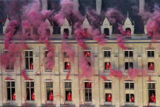 Smoke billows near windows as performers participate during the opening ceremony of the 2024 Summer Olympics, Friday, July 26, 2024, in Paris, France. (AP Photo/Bernat Armangue, Pool)