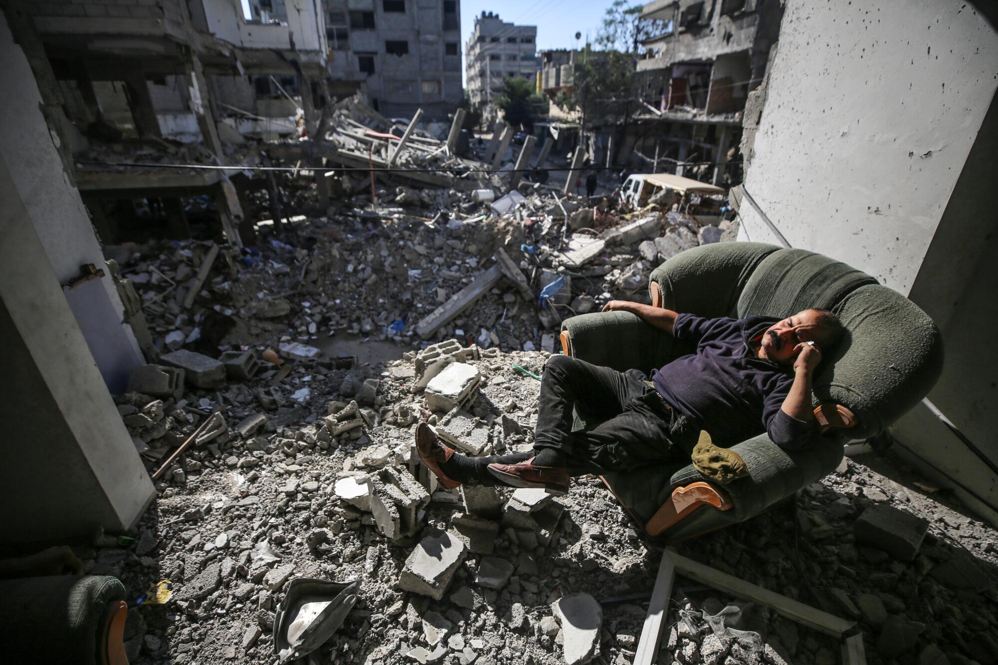 A man sitting in a chair amid rubble. 