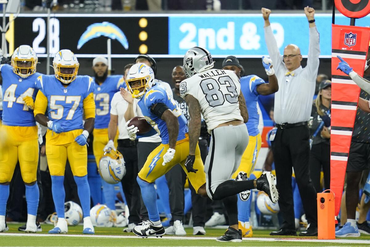 Chargers safety Derwin James runs with the ball after intercepting a pass intended for Raiders tight end Darren Waller.