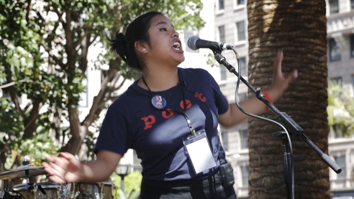 High school senior Vanessa Tahay recites a poem during an event at Pershing Square.