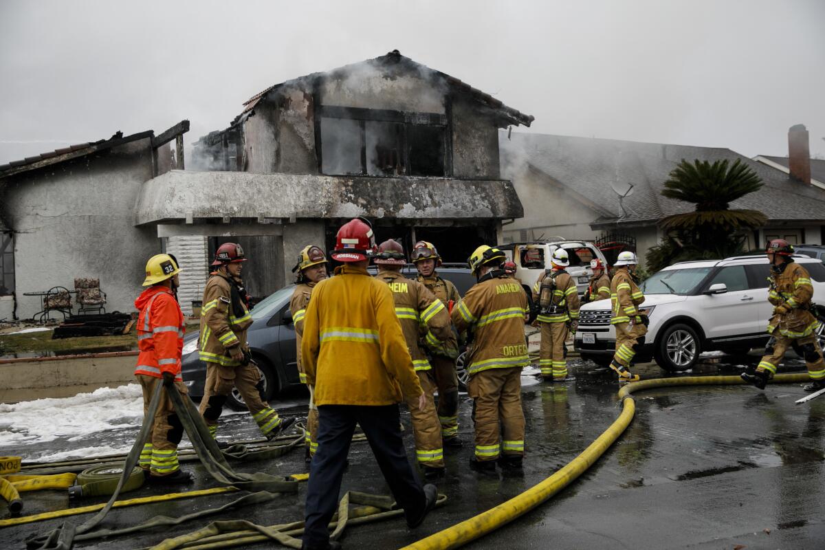 Firefighters tackle a structural blaze caused by a plane crash in Yorba Linda on Feb. 3.