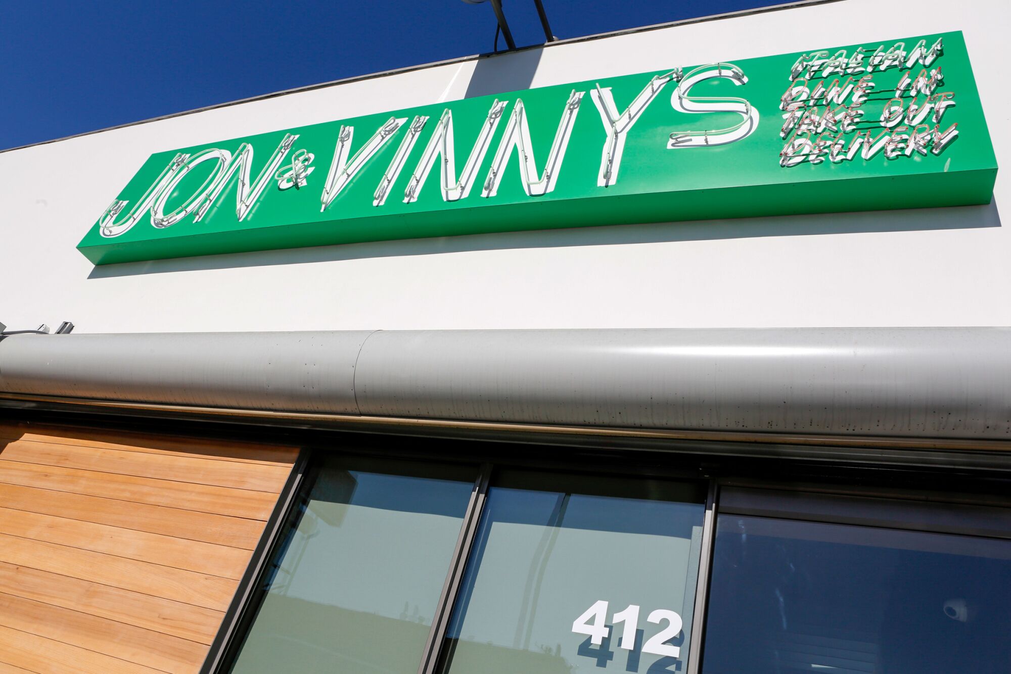 A sign reads, "Jon & Vinny's: Italian, Dine In, Take Out, Delivery"