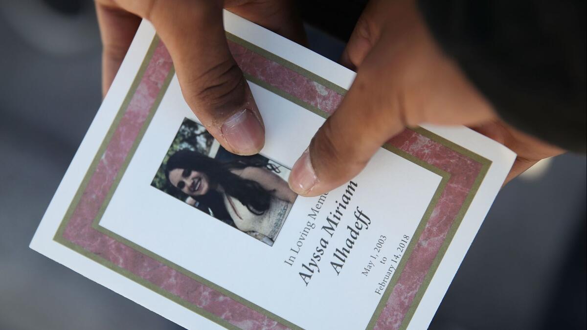 A mourner holds a program from the funeral of Alyssa Alhadeff.