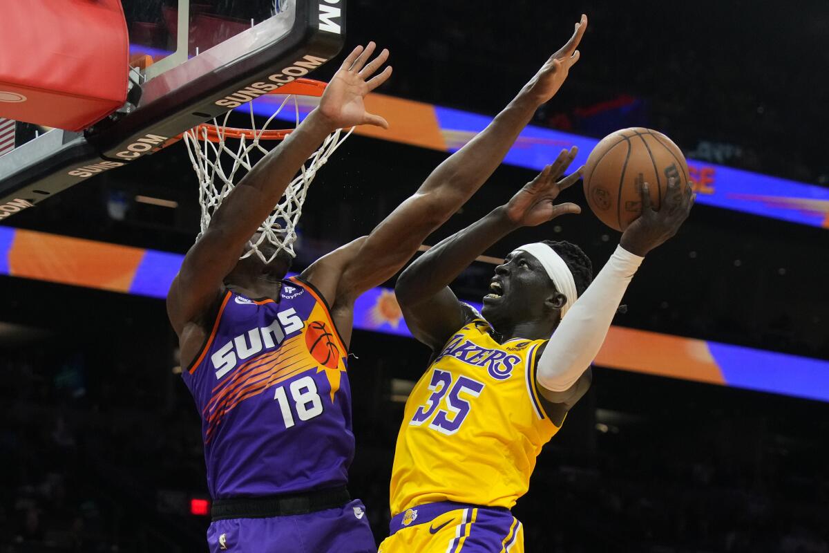 Lakers forward Wenyen Gabriel drives to the basket against Phoenix Suns center Bismack Biyombo.
