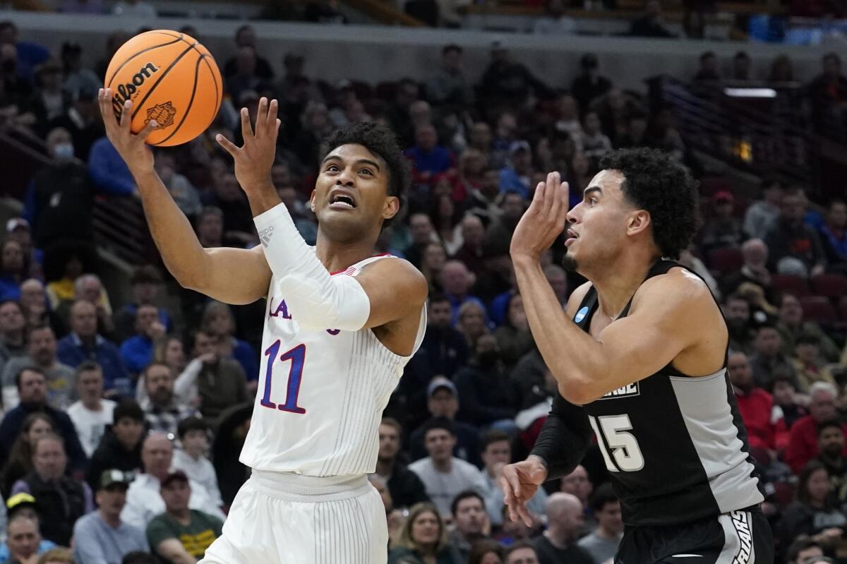 Kansas' Remy Martin shoots past Providence's Justin Minaya during the first half March 25, 2022, in Chicago.