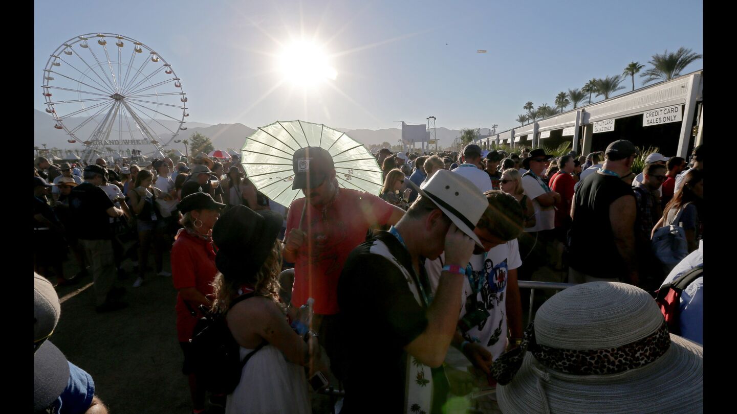 The sun beats down on huge crowds waiting to buy merchandise at Desert Trip.