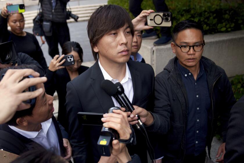 FILE - Ippei Mizuhara, center, the former longtime interpreter for the Los Angeles Dodgers baseball star Shohei Ohtani, leaves federal court following his arraignment, Tuesday, May 14, 2024, in Los Angeles. Mizuhara is scheduled to plead guilty Tuesday, June 4, 2024, to bank and tax fraud in a sports betting case where he is expected to admit to stealing nearly $17 million from the Japanese baseball player. (AP Photo/Eric Thayer, File)