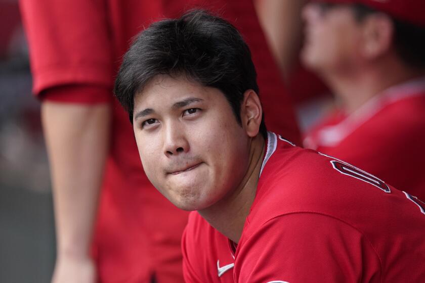 Los Angeles Angels' Shohei Ohtani sits in the dugout during the first inning.