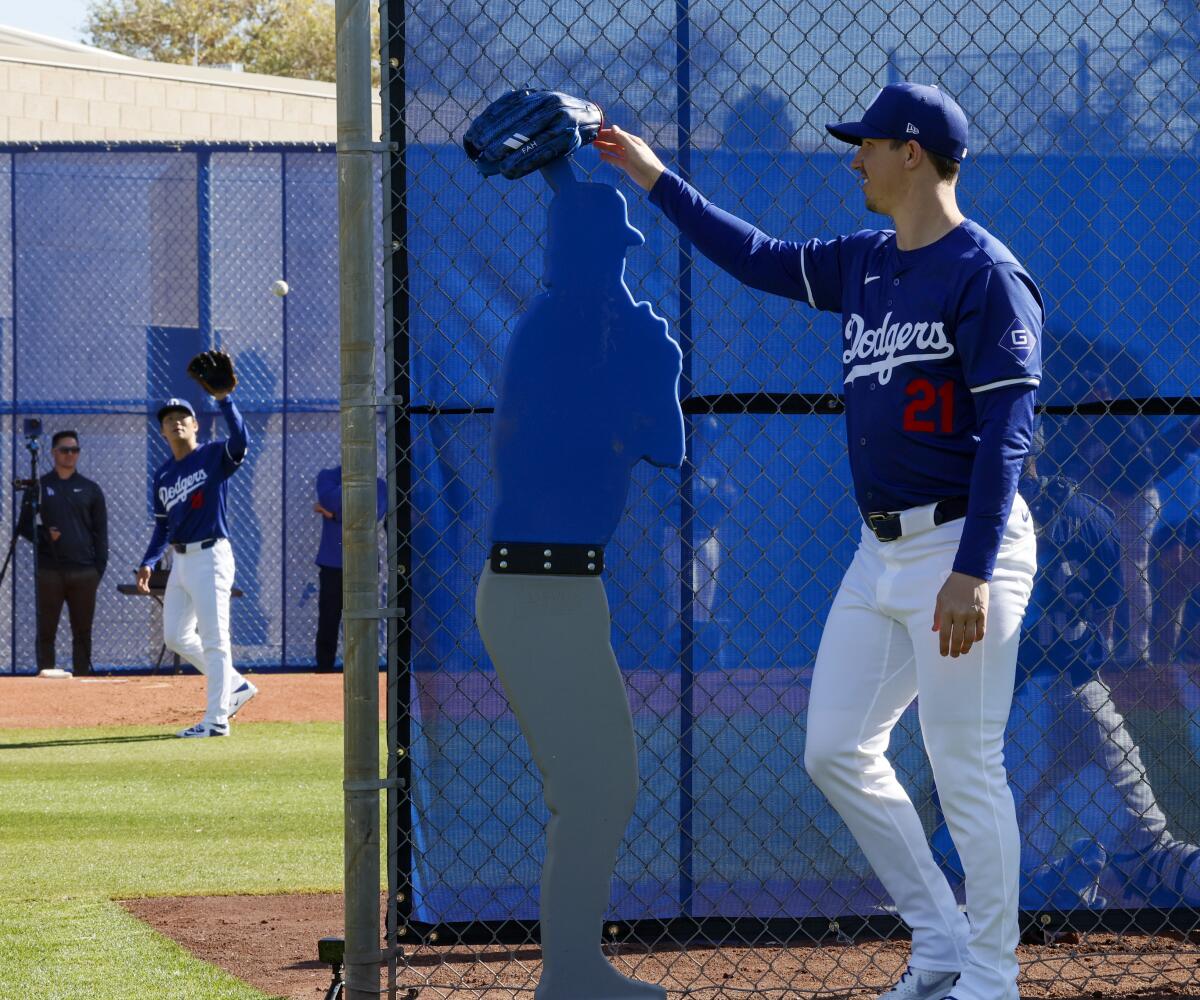 Los Angeles Dodgers' Walker Buehler looks on as teammate Yoshinobu Yamamoto throws a bullpen session