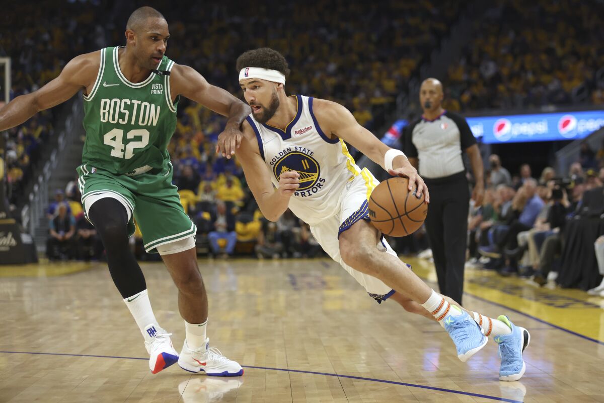 Golden State Warriors guard Klay Thompson drives to the basket against Boston Celtics center Al Horford.