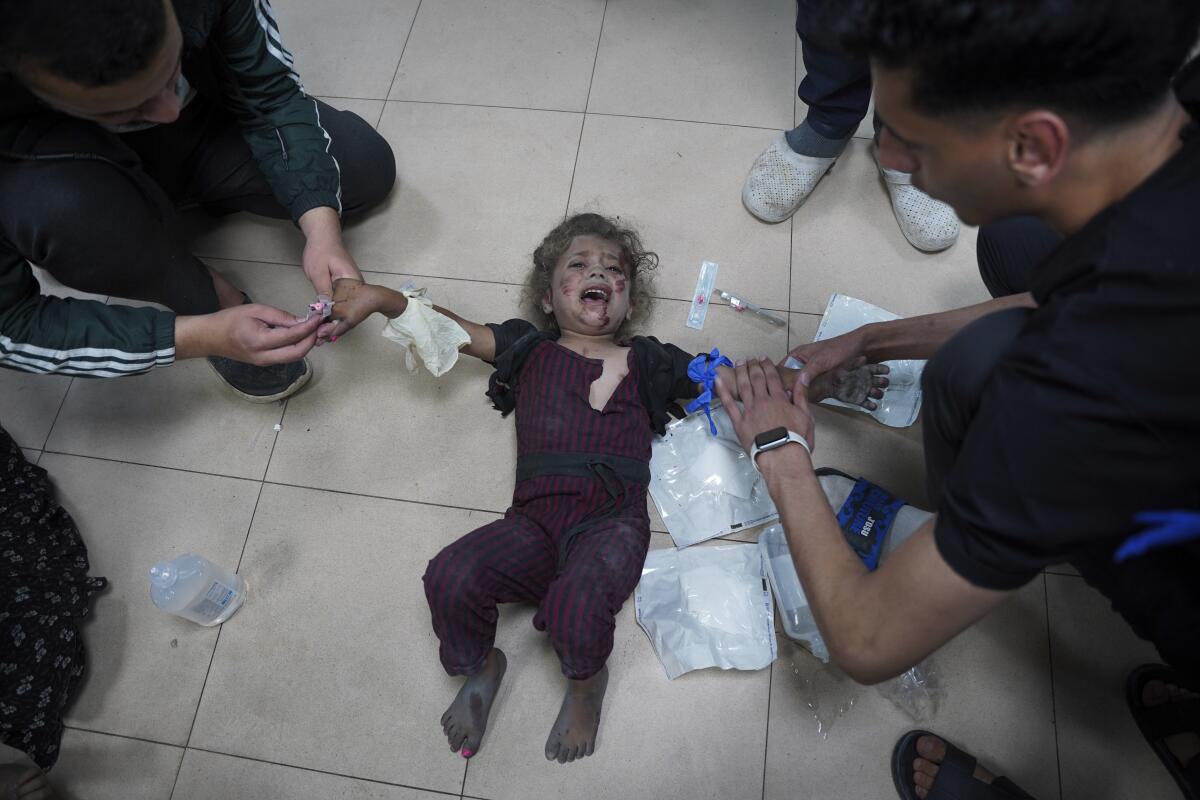 Medics treat a wounded baby at Al Aqsa Martyrs Hospital in Deir al Balah, Gaza Strip, on Saturday.