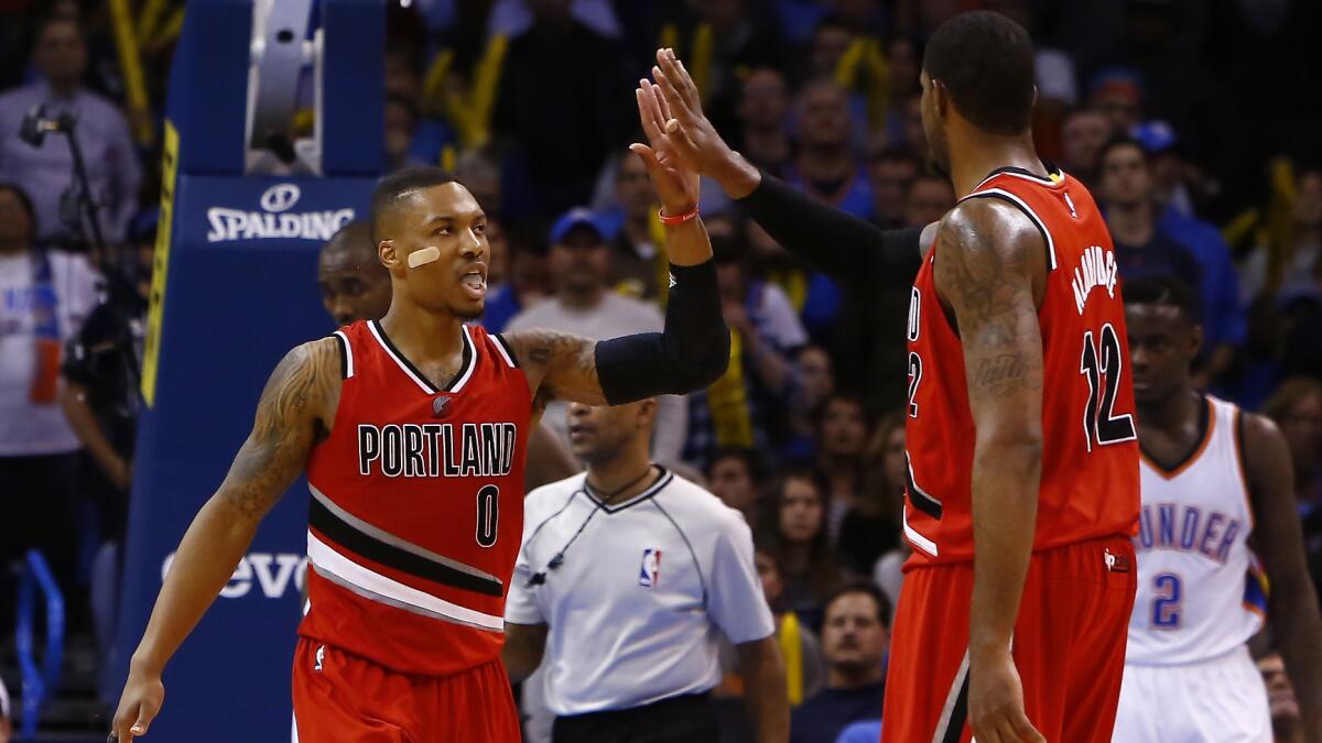 Portland Trail Blazers guard Damian Lillard (0) celebrates with teammate LaMarcus Aldridge after scoring a three-pointer in a win over the Oklahoma City Thunder on Dec. 23.