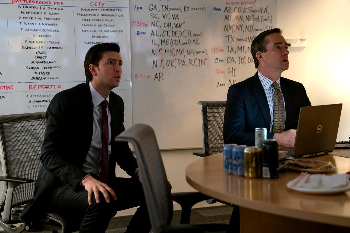 Nicholas Braun, Matthew Macfadyen sit in front of white boards tracking election tallies in a scene from "Succession."