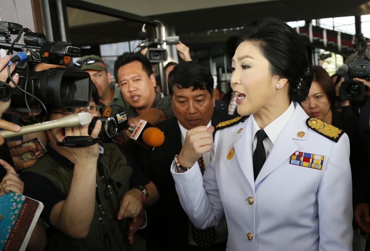 Then-Thai Prime Minister Yingluck Shinawatra speaks to reporters as she leaves a meeting with election commissioners at the Army Club in Bangkok on Jan. 28, 2014.