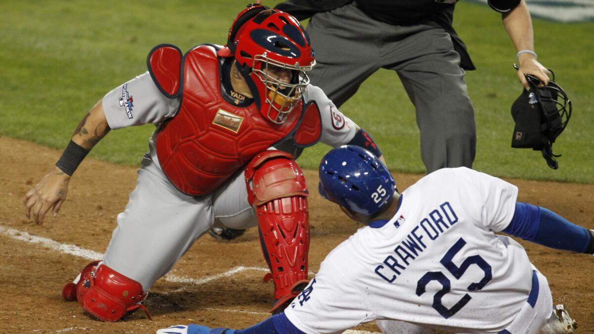 Dodgers baserunner Carl Crawford, right, scores under the tag of St. Louis Cardinals catcher Yadier Molina during Game 3 of the 2013 National League Championship Series. Molina figures to play a prominent role against the Dodgers again.