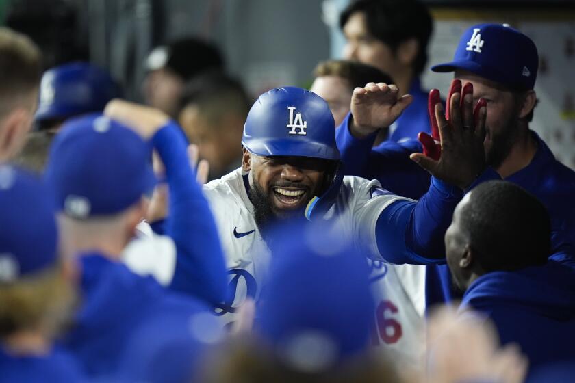 Los Angeles Dodgers' Teoscar Hernandez, center, is congratulated by teammates after hitting a home run.