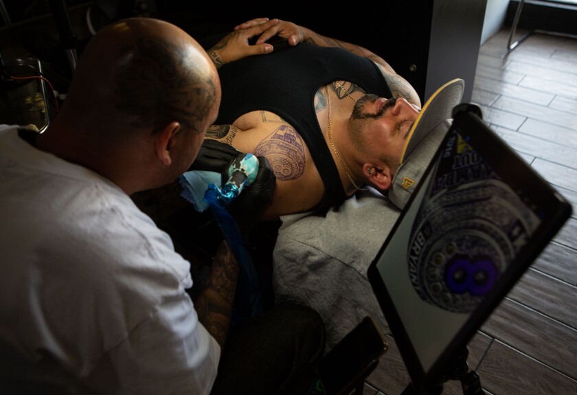 Jose Guijosa works on a tattoo commemorating Kobe Bryant