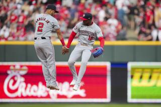 Luis García Jr. y el dominicano Víctor Robles, de los Nacionales de Washington, festejan la victoria sobre los Rojos de Cincinnati, el sábado 30 de marzo de 2024 (AP Foto/Aaron Doster)