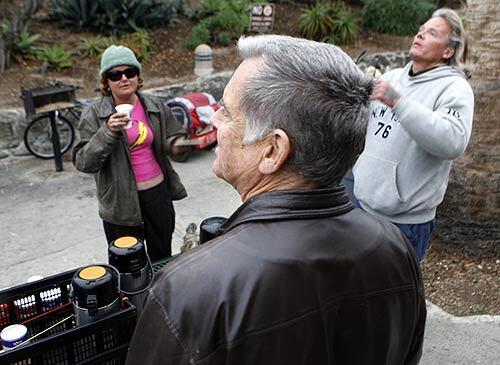 Laguna Beach resident Jim Keegan (center, with back to camera) serves coffee in the mornings to the homeless at Heisler Park. The ACLU filed a suit March 19 alleging that the city of Laguna Beach harasses the chronically homeless who camp out in the beach-side community.