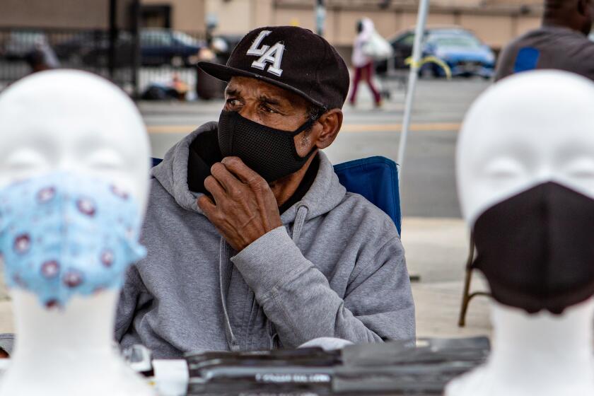 SOUTH LOS ANGELES, CA - APRIL 05: On the corner of Western and Manchester Avenue in South Los Angeles Larry Hickman of Los Angeles sells a variety of face mask on Sunday, April 5, 2020 in Los Angeles, CA. Hickman said he feel like he is providing a great service and filling a need in his community. (Jason Armond / Los Angeles Times)