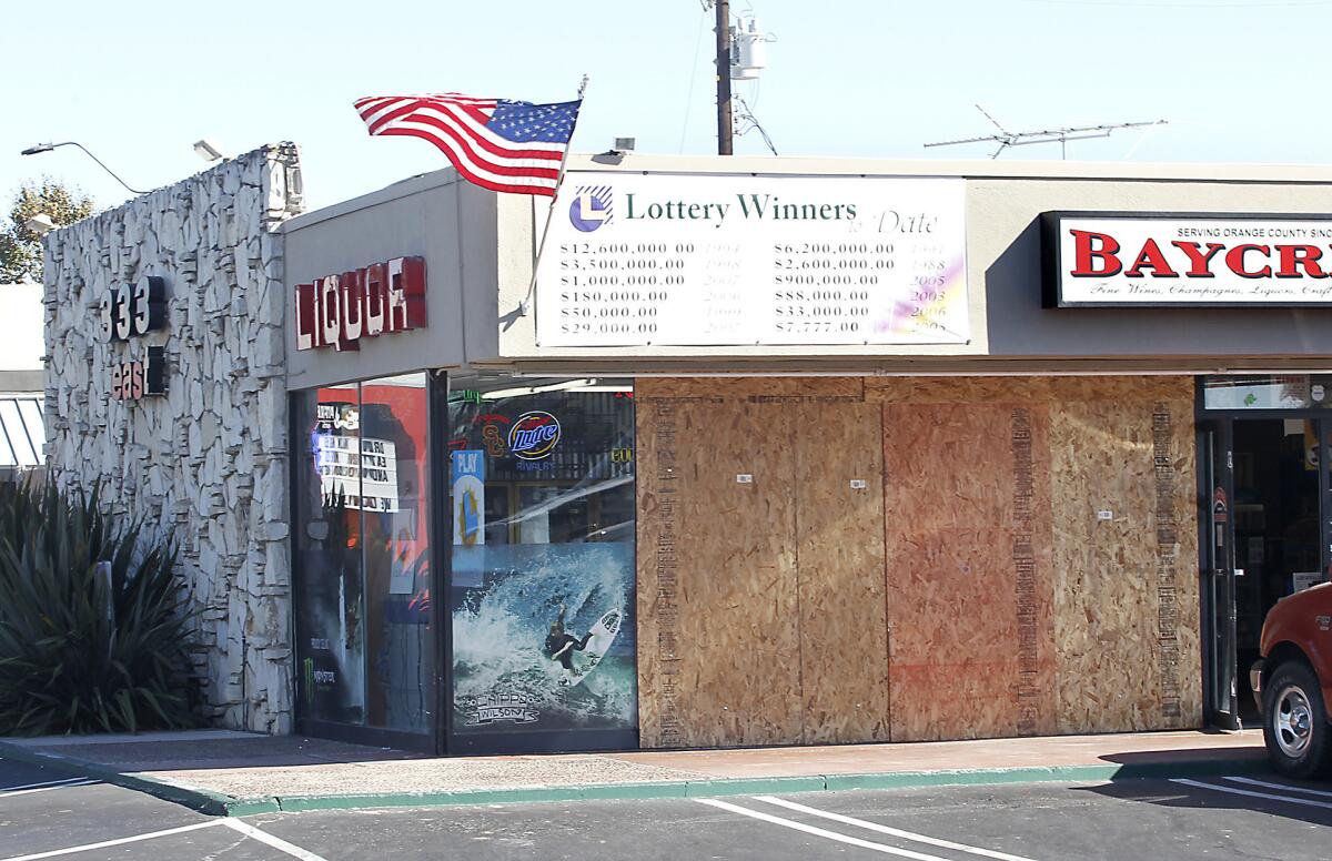 Plywood boards cover the front of Baycrest Liquor after a truck crashed through the window and stole an ATM machine early Wednesday. The store is known for its good luck in lotto winnings.
