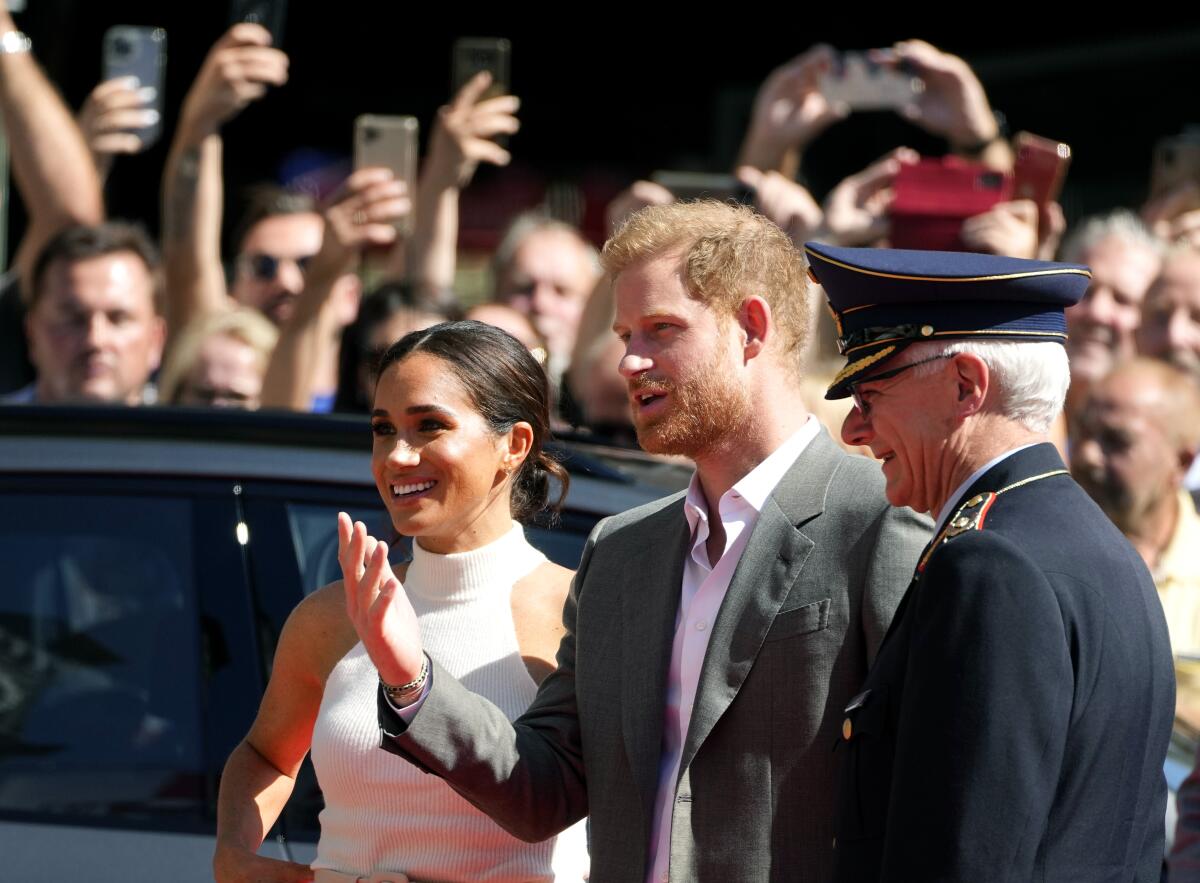 Britain's Prince Harry, 2nd right, and Meghan, Duchess of Sussex, arrive for a visit at the town hall in Duesseldorf, Germany, Tuesday, Sept. 6, 2022. Prince Harry visits the city as ambassador for the Invictus games, a week-long games for active servicemen and veterans who are ill, injured or wounded, hosted by Duesseldorf next year. (AP Photo/Martin Meissner)